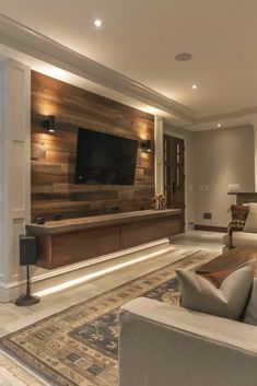 a living room with couches and a flat screen tv mounted on the wall above it