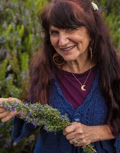 an older woman holding flowers in her hands