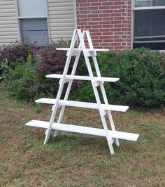 a white wooden shelf sitting in the grass