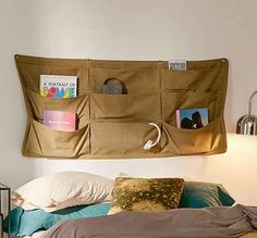 a bed with two pillows and some pictures hanging on the wall