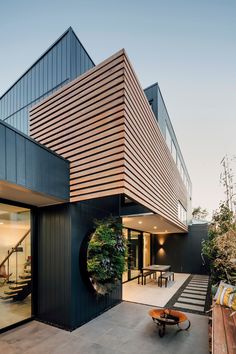 a modern house with an outdoor seating area and wooden slats on the outside wall