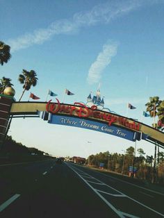 the entrance to disney world with a red man running under it