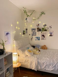 a white bed sitting in a bedroom next to a book shelf filled with stuffed animals