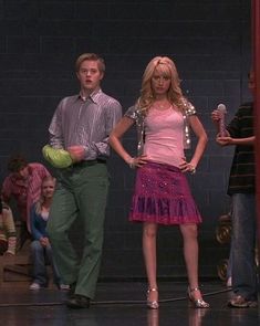 two people standing in front of a group of other people, one holding a frisbee