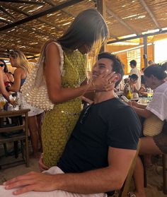 a man covering his face while sitting next to a woman