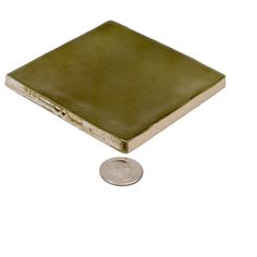 a small green book sitting on top of a coin