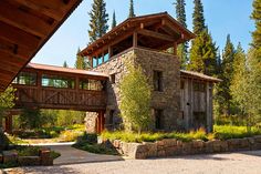 a stone building with trees in the background and a bridge over it that leads to another building