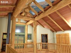 the inside of a house with wooden beams and windows