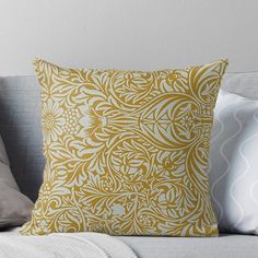 a yellow and white pillow sitting on top of a couch next to a gray throw pillow