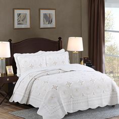 a bed with white bedspread and two lamps