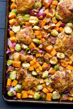 a pan filled with meat and vegetables on top of a wooden table