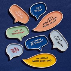 six ceramic speech bubbles with words written on them, all in different colors and sayings