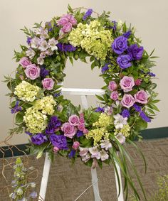 a purple and green wreath sitting on top of a white chair