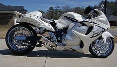 a white motorcycle parked on top of a driveway