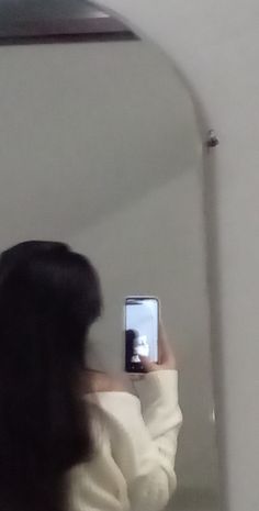 a woman taking a selfie in front of a mirror