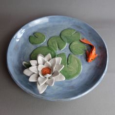 a bowl with water lilies and fish in it