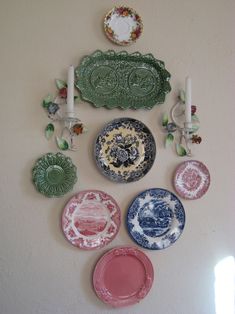 a wall mounted with plates and candles on it