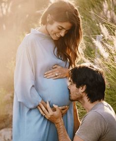 a pregnant woman is standing next to a man