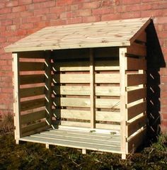 a wooden shed sitting next to a brick wall