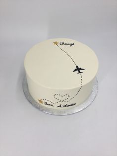 a white cake with an airplane drawn on the side and stars painted on the top