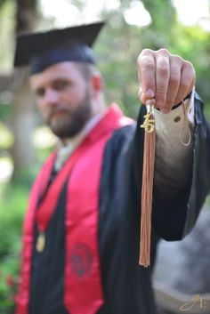 a man wearing a graduation gown and holding a tassel