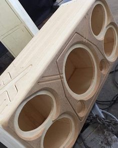 a large wooden object sitting on top of a piece of wood with holes in it