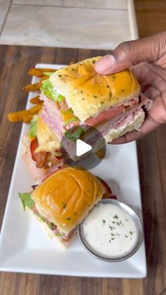 a person is holding up a sandwich on a plate