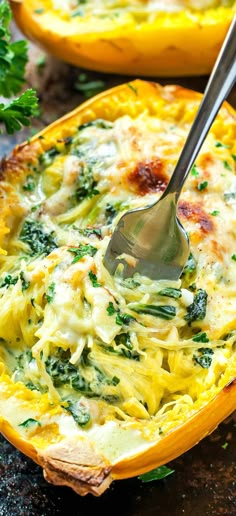 a spoon in a casserole dish with spinach and cheese on the side