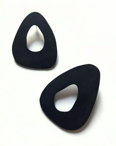 two pieces of black plastic sitting on top of a white surface