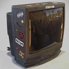 an old television with stickers on the screen