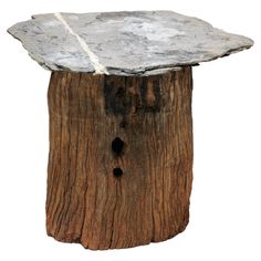 a piece of wood that has been turned into a table with a stone top on it