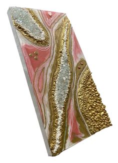 a piece of art that is made out of gold and pink marbled paper with glitters on it