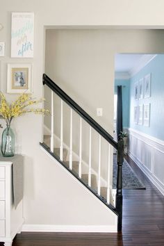 there is a vase with yellow flowers on the table in front of the stair case