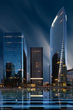 the city is lit up at night with skyscrapers and other buildings in the background