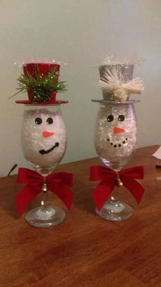 two wine glasses decorated like snowmen with red bows