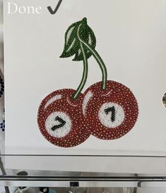 two cherries with numbers on them are made out of bead and sequins