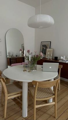 a white table with two chairs around it and a laptop on top of the table