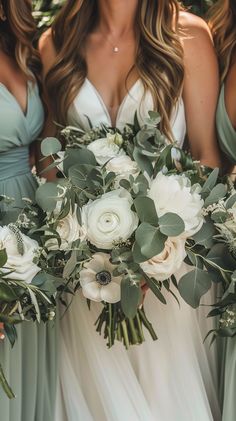 the bridesmaids are holding their bouquets with white flowers and greenery on them