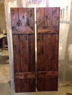 two wooden doors sitting next to each other on top of a floor in a room