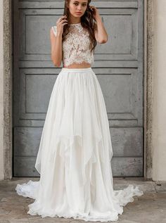 a woman standing in front of a door wearing a white dress