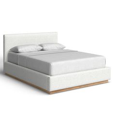 the bed is made up with white linens and wood feetplashes on each side