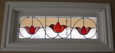 a close up of a stained glass window with red flowers in the center and white frame