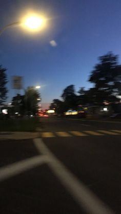 an empty parking lot at night with street lights in the background