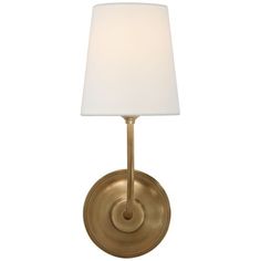 a gold wall light with a white shade on the top and bottom half of it