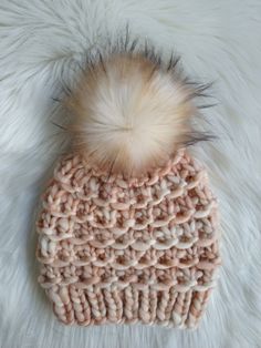 a knitted hat with a fur pom