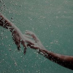 a hand reaching out from the water to grab something in it's hands with bubbles