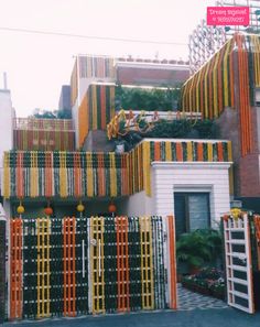 an orange and yellow fence is in front of a building with many balconies