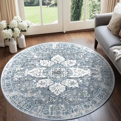 a living room area with a large rug on the floor next to a couch and windows