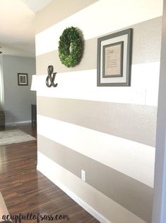 the wall is painted with gray and white stripes, which are accented with a wreath