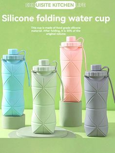 four different colored cups sitting next to each other on top of a green countertop